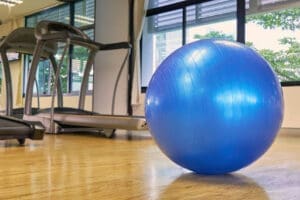 A big blue ball sits in a gym.