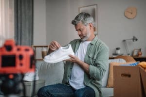 A man with gray hair examines an orthopedic sneaker.